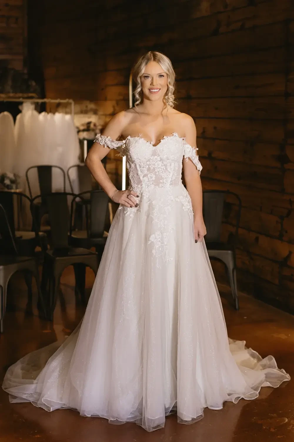 model is wearing a romantic off the shoulder bridal gown